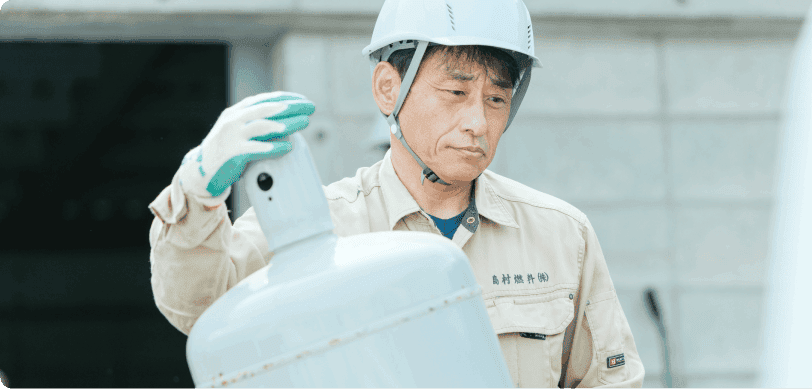 LPガスボンベを運ぶベテランスタッフ