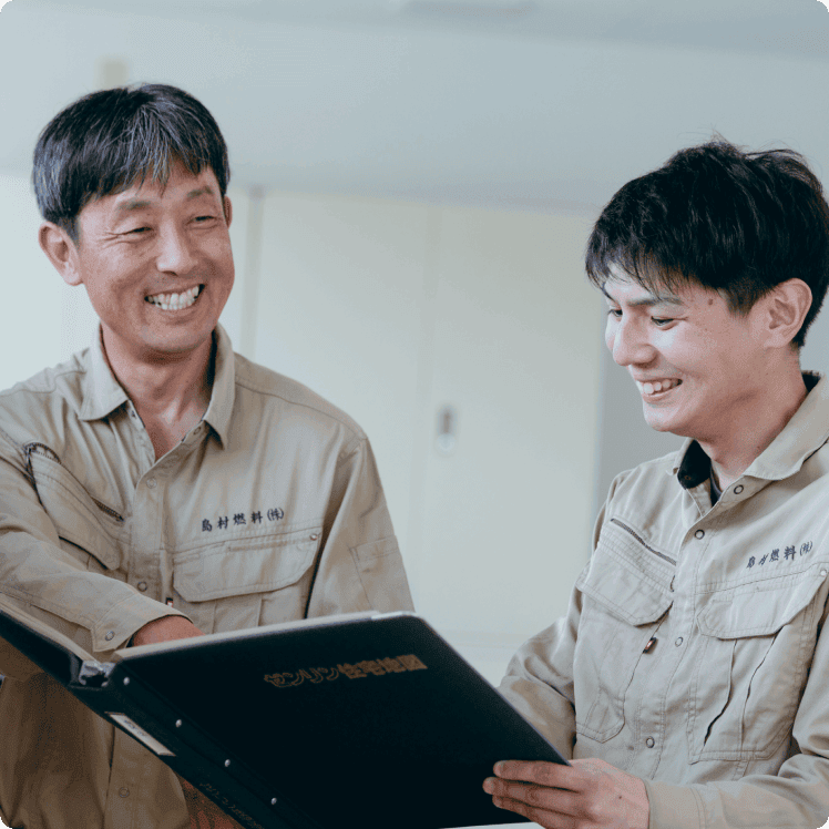 書類を見ながら笑顔で話す先輩と後輩スタッフ