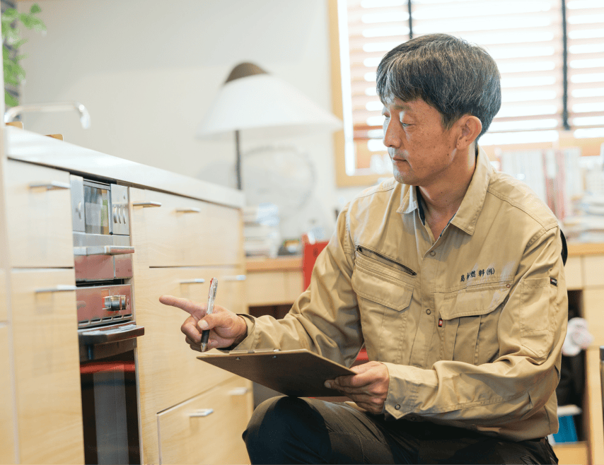 お客さま宅で設備の説明をするスタッフ