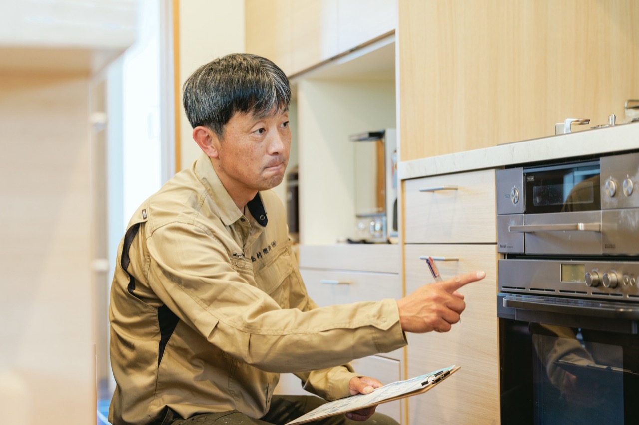 キッチンでガス機器の状態を確認するスタッフ