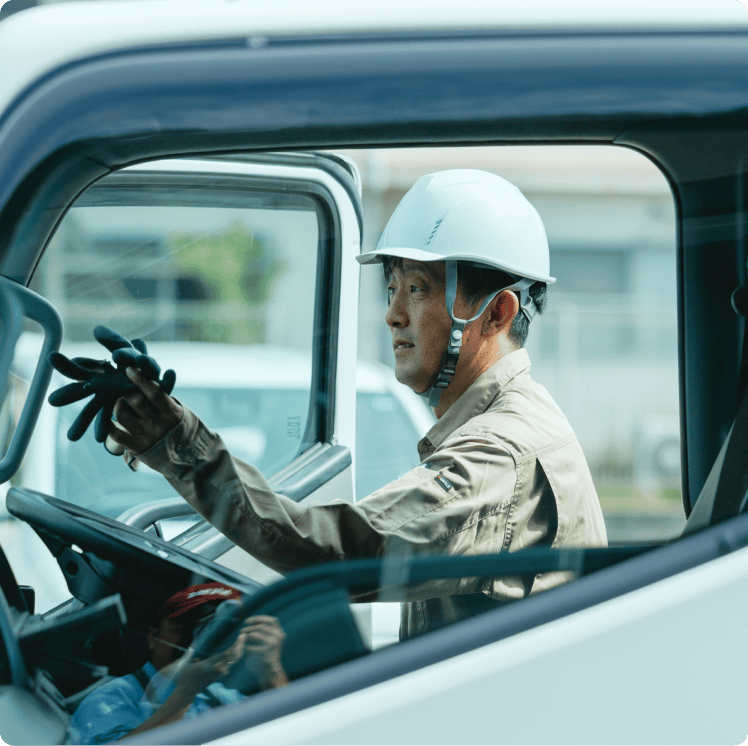 配送車の運転席に乗り込むスタッフ
